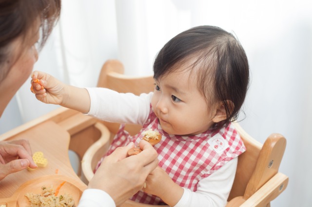 離乳食を食べる赤ちゃんと3回食を始める時期のイメージ